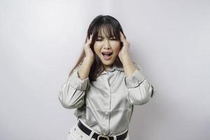 A portrait of an Asian woman wearing a sage green shirt isolated by white background looks depressed photo