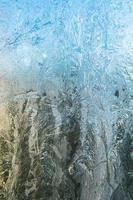 Frozen winter window with shiny ice frost pattern texture. Christmas wonder symbol, abstract background. Extreme north low temperature, natural Ice snow on frosty glass, cool winter weather outdoor. photo