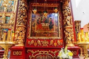 Iglesia Ortodoxa. cristiandad. decoración interior festiva con velas encendidas e icono en la iglesia ortodoxa tradicional en vísperas de pascua o navidad. religión fe orar símbolo. foto