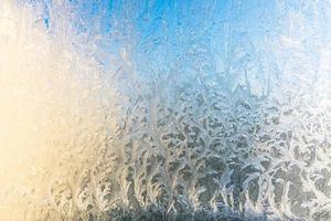 ventana de invierno congelada con textura de patrón de escarcha de hielo brillante. símbolo de maravilla de navidad, fondo abstracto. baja temperatura del extremo norte, nieve de hielo natural sobre vidrio escarchado, clima frío de invierno al aire libre. foto