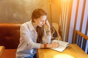 Young girl playing guitar in cafe photo