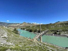 puentes viejos y nuevos a través del río katun en el pueblo de inya, altai, rusia foto