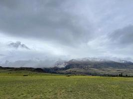 Clouds lying on the tops of snow-capped mountains in the Altai mountains photo