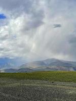 Rain cloud and rain coming from it in the Altai mountains photo