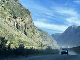 Car driving on a country road in the Altai mountains photo