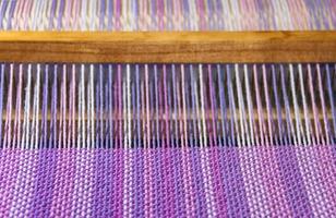 detail of fabric in comb loom with ultraviolet and lilac colors photo