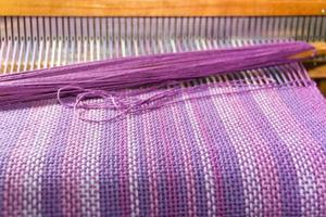 detail of fabric in comb loom with ultraviolet and lilac colors photo