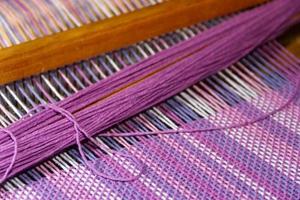 detail of fabric in comb loom with ultraviolet and lilac colors photo