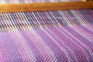 detail of fabric in comb loom with ultraviolet and lilac colors photo