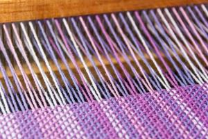 detail of fabric in comb loom with ultraviolet and lilac colors photo