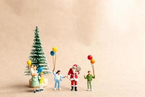 Miniature people, Santa Claus delivering a gift package to children photo