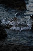 Sea waves crashing into rocks photo