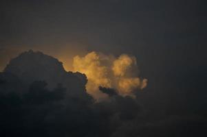 Dark clouds, clouds on in the dark sky. Stormy weather, sun shining through the clouds. photo