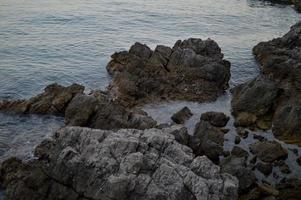 Rocks at the beach, calm water photo