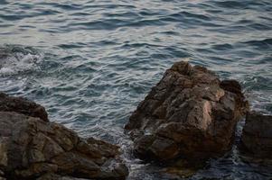 Sea waves crashing into rocks. photo