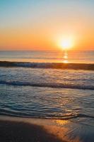 Beautiful summer sunset at the beach, waves and sand photo