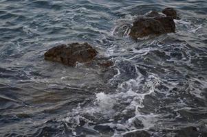 olas del mar chocando contra las rocas. foto