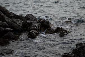 Sea waves crashing into rocks photo