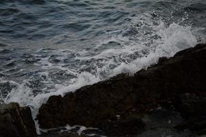 olas del mar chocando contra las rocas. foto