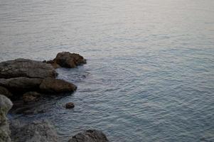 Rocks at the beach, calm water photo