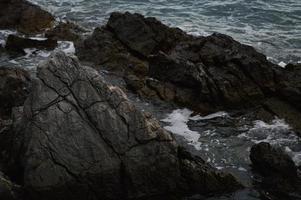 Sea waves crashing into rocks. photo