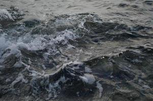 Sea waves crashing into rocks, close up water photo