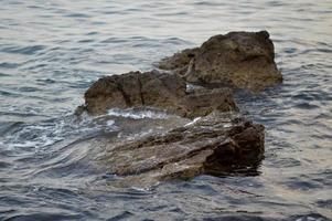 Rocks at the beach, calm water photo