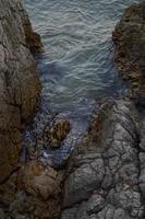 rocas en la playa, aguas tranquilas foto