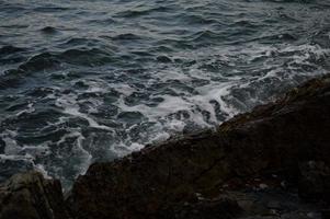 Sea waves crashing into rocks. photo