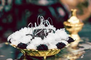 Medals for altar were wrapped in black and white mulberry paper and ribbons, beautifully arranged on golden yellow tray. Blurred back for gravel. Empty space for entering text. photo