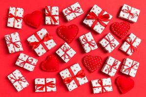 vista superior de cajas de regalo blancas y corazones textiles rojos sobre fondo colorido. concepto del día de san valentín