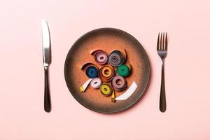 Healthy diet concept of plate with measuring tape, fork and knife on pink background. Top view photo