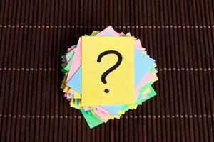 Concept for confusion, question or solution. question mark on wooden background photo