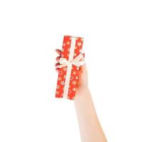 Woman hands give wrapped Christmas or other holiday handmade present in red paper with Gold ribbon. Isolated on white background, top view. thanksgiving Gift box concept photo