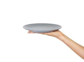 Blank empty round gray matte plate in female hand. perspective view, isolated on white background photo