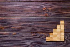 A wooden blocks cube over black wooden textured background with copy space for add word text title. Concept or conceptual Wood block stair or five steps. Cubic photo