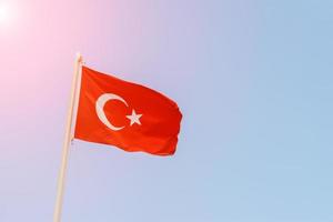 Turkish flag on the background of the sky in sunny day photo