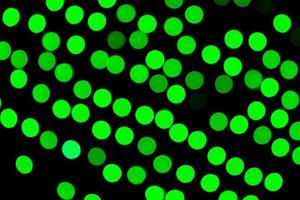 Unfocused abstract green bokeh on black background. defocused and blurred many round light photo