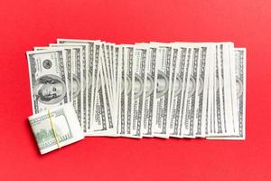 primer plano de billetes de 100 dólares en una fila sobre fondo de colores. vista superior del concepto de salario foto