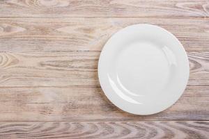 Empty white plate on wooden table. Template for your design. photo