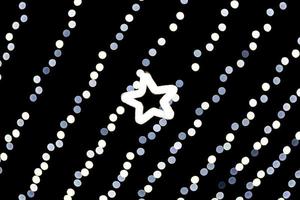 Unfocused abstract white bokeh with star of light on black background. defocused and blurred many round light photo