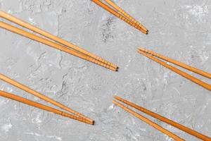 Many bamboo chopsticks on black cement stone background, top view with copy space. a lot of sushi sticks in the form of an ornament photo