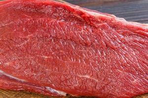 Texture of fresh raw beef meat on wooden table photo