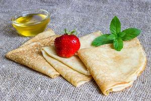 Delicious pancakes with strawberries and honey photo