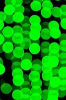 Unfocused abstract green bokeh on black background. defocused and blurred many round light photo