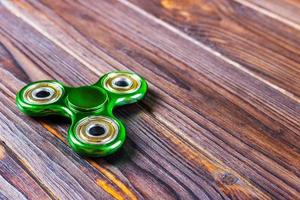 Spinner fidget toy for stress relieving on wood table background with copy space for your creative design project photo