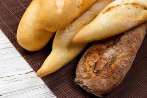 Assortment of fresh French baguettes on a wooden table photo