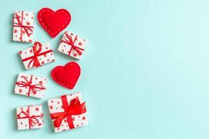 composición navideña de cajas de regalo y corazones textiles rojos sobre fondo colorido con espacio vacío para su diseño. vista superior del concepto del día de san valentín