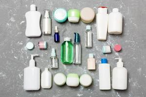 grupo de botellas de plástico para el cuidado del cuerpo composición plana con productos cosméticos sobre fondo verde espacio vacío para su diseño. conjunto de envases cosméticos blancos, vista superior con espacio de copia foto