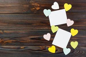 Empty paper over wooden background with colorful heart on valentines day photo